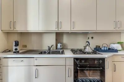 a kitchen with white cabinets and a sink and a stove at La Casa di Taumasia in Rome