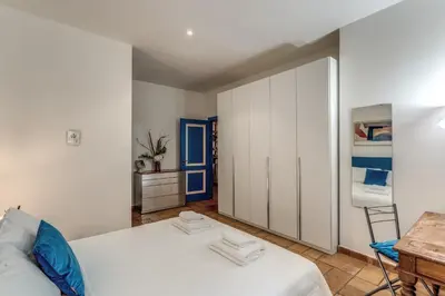 a bedroom with a white bed and a blue door at La Casa di Taumasia in Rome