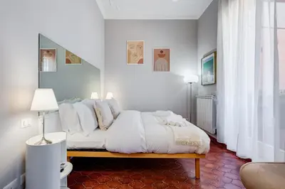 a white bedroom with a bed with white pillows at Terrace with a view of Rome in Rome
