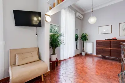 a living room with a couch and a tv on a wall at Terrace with a view of Rome in Rome