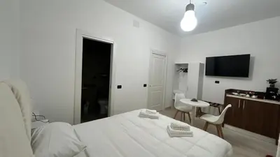a white bedroom with a bed and a table and chair at Antony house in Rome