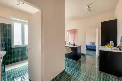 a bathroom with a shower and a green tile floor at Cipria Luxury Apartment in Rome