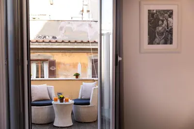 a room with a balcony with chairs and a window at Relais Monti in Rome