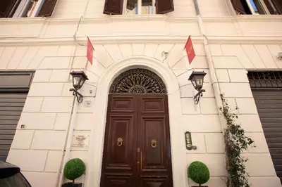 a building with a brown door with two flags above it at Relais Monti in Rome