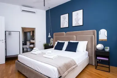 a bedroom with a large bed with blue walls at Piazza Navona Elegant Apartment in Rome