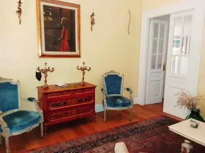 a living room with two blue chairs and a dresser at Private room by an Italian family - A unique experience close to Colosseum, the Roman Forum and Basilica Saint Mary Major in Rome