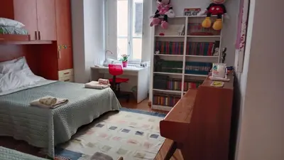 a bedroom with a bed and a desk and bookshelves at Private room by an Italian family - A unique experience close to Colosseum, the Roman Forum and Basilica Saint Mary Major in Rome