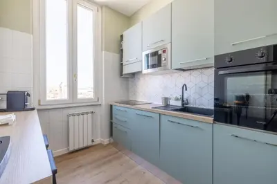 a kitchen with white cabinets and a sink at Dolce Vita Penthouse in Rome