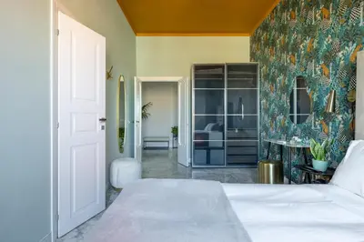 a bedroom with a white bed and a colorful wall at Dolce Vita Penthouse in Rome