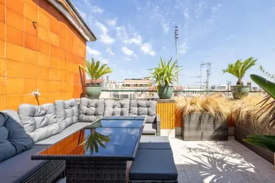 a patio with a couch and a table at Dolce Vita Penthouse in Rome