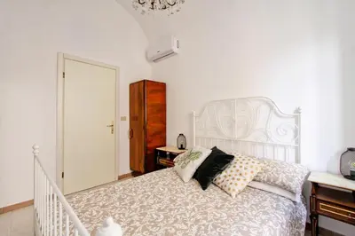 a bedroom with a white bed and a chandelier at BigFamilyFlats - Colosseo&Monti - ROOMS in Rome