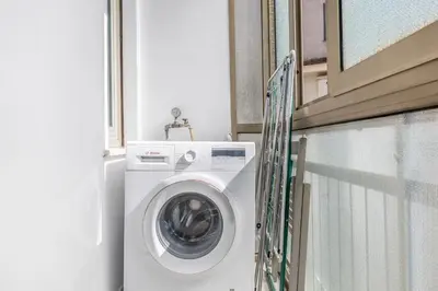 a washing machine in a bathroom next to a window at Casa Malupa Luxury Apts San Giovanni in Laterano in Rome