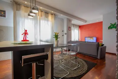 a kitchen and living room with a table and a couch at 8bit Dreams - Al Pigneto - 100 m da Metro Malatesta in Rome