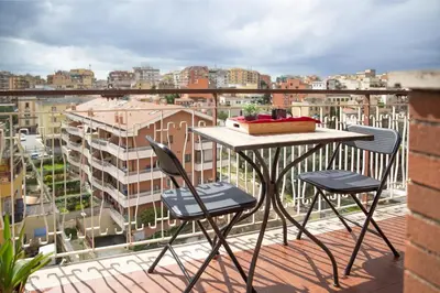 a table and chairs on a balcony with a view of a city at 8bit Dreams - Al Pigneto - 100 m da Metro Malatesta in Rome