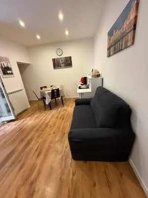 a living room with a black couch and a table at La Dimora di Sara a 10 minuti da Termini in Rome