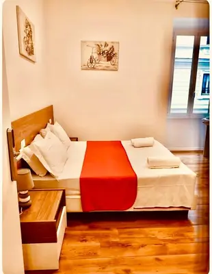 a bedroom with a bed with a red and white blanket at La Dimora di Sara a 10 minuti da Termini in Rome