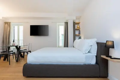 a bedroom with a bed and a dining room at Amazing Via del Corso 277 Suites in Rome
