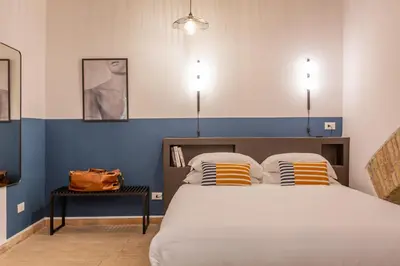 a bedroom with a bed with blue and white walls at Glam Nest & Garden Colosseum in Rome