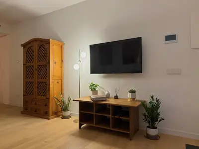 a living room with a flat screen tv on a wall at Suite with Private Courtyard - Colosseum & Forum in Rome