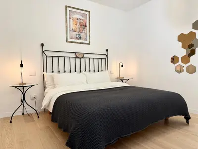 a bedroom with a large bed with a black blanket at Suite with Private Courtyard - Colosseum & Forum in Rome