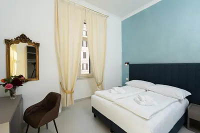 a bedroom with a bed and a mirror and a chair at Alida Rooms in Rome
