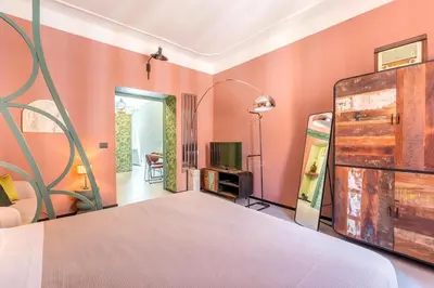 a bedroom with pink walls and a bed with a wooden headboard at B HOUSE - luxury apartment Trastevere in Rome