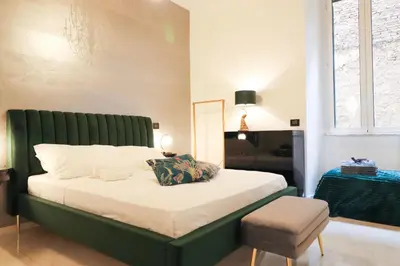 a bed with a green headboard in a bedroom at FLORA- Loft Luxury - tra Colosseo e Santa Maria Maggiore - Metro in Rome