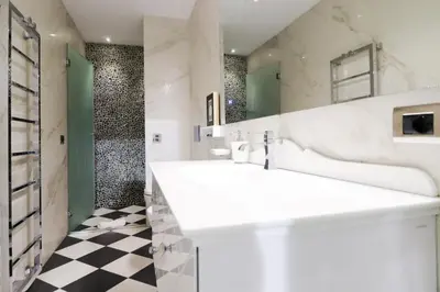 a bathroom with a white sink and a checkered floor at FLORA- Loft Luxury - tra Colosseo e Santa Maria Maggiore - Metro in Rome