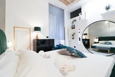 a living room with a white couch and a mirror at FLORA- Loft Luxury - tra Colosseo e Santa Maria Maggiore - Metro in Rome