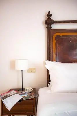 a bedroom with a bed and a table with a lamp at Colosseum Suites - Zen 22 in Rome