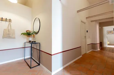 a hallway with white walls and a mirror and a table at Colosseum Suites - Zen 22 in Rome