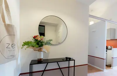 a mirror on a wall next to a table with flowers at Colosseum Suites - Zen 22 in Rome