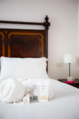 a bed with two towels and a pile of pillows at Colosseum Suites - Zen 22 in Rome