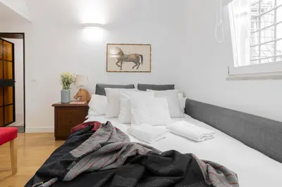 a bedroom with a white bed with white pillows at Trilussa Spacious Apartment in Rome
