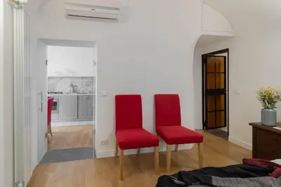 two red chairs sitting in a living room at Trilussa Spacious Apartment in Rome