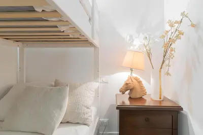 a bedroom with a bed and a table with a lamp at Trilussa Spacious Apartment in Rome
