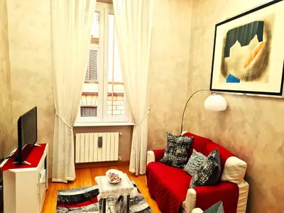 a living room with a red couch and a window at Chez Pierre tourist rental in Rome