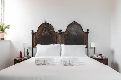a large white bed with a large wooden headboard at Colosseum suites apartment - Zen 22 in Rome