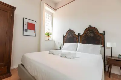 a bedroom with a large white bed with a wooden headboard at Colosseum suites apartment - Zen 22 in Rome