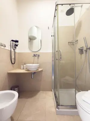 a bathroom with a glass shower and a sink at Colosseum suites apartment - Zen 22 in Rome