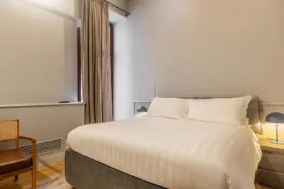 a bedroom with a large white bed and a chair at Spiriti Home Apartment 2, New Opening Piazza di Pietra in Rome