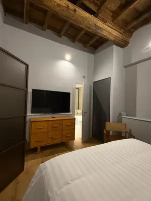a bedroom with a bed and a flat screen tv at Spiriti Home Apartment 2, New Opening Piazza di Pietra in Rome