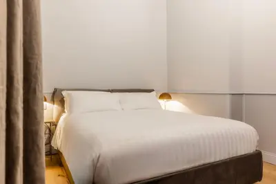 a bedroom with a white bed with two lamps at Spiriti Home Apartment 3, New Opening Piazza di Pietra in Rome