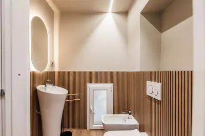a bathroom with a sink and a toilet and a mirror at The Best Rent - Atmosphere and romance: one-bedroom apartment just steps from the Colosseum in Rome