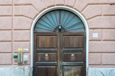 a wooden door in a brick wall with a window at The Best Rent - Atmosphere and romance: one-bedroom apartment just steps from the Colosseum in Rome