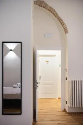 a mirror in a room with a bed and a door at By Lina in Trastevere in Rome