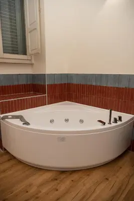 a bath tub in a bathroom with red tiles at By Lina in Trastevere in Rome