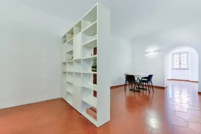 a large white book shelf in a room with a table at Lavinia's Apartment at Colosseo in Rome
