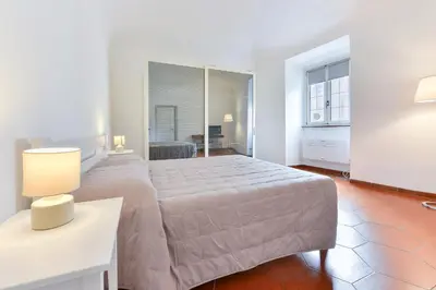 a bedroom with a bed and a table with a lamp at Lavinia's Apartment at Colosseo in Rome