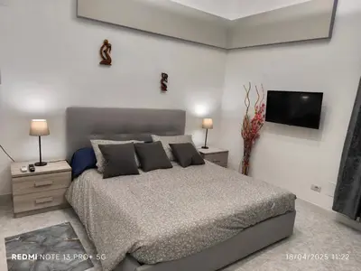 a bedroom with a bed and a flat screen tv at Maison Vittoria in Rome
